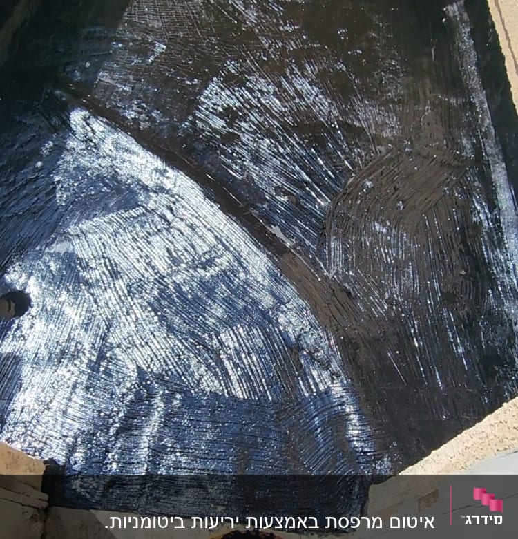 משטח אטום בזפת עם דלי זפת בצד